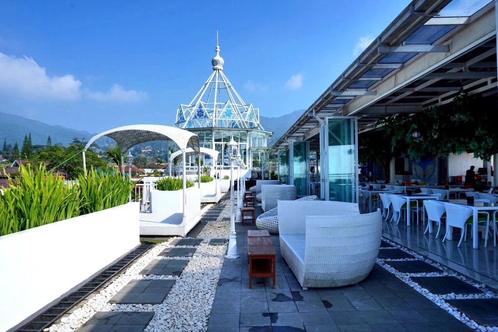 Rooftop area villa dengan pemandangan gunung dan langit biru yang luas di Bogor.