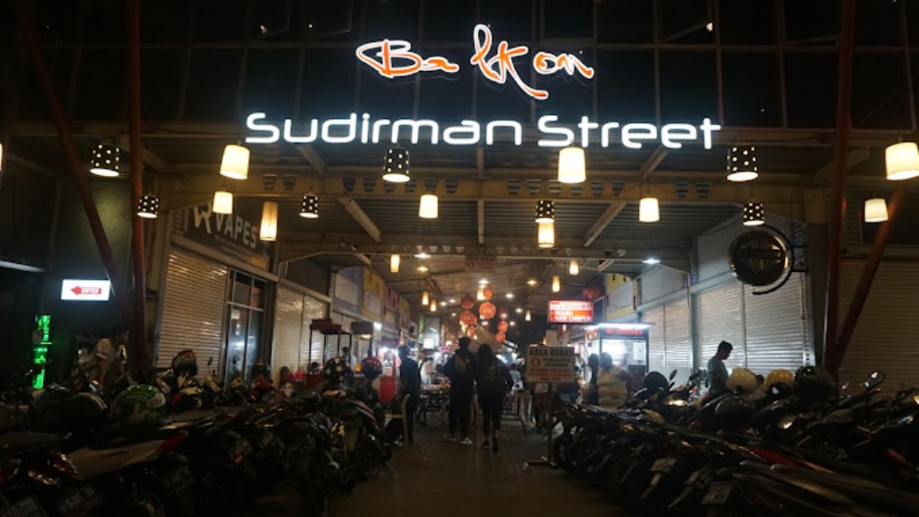 Suasana malam hari di Sudirman Street Day & Night Market dengan lampu-lu.