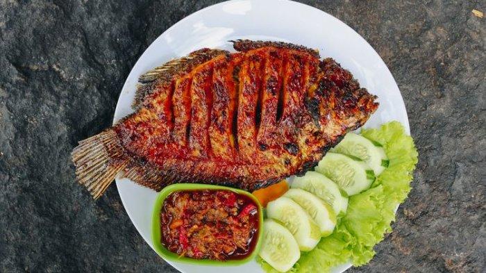 Piring besar berisi ikan bakar dengan sambal dan lalapan.