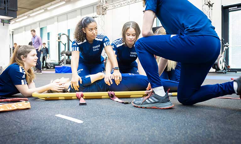 Gambar siswa-siswi sedang berpartisipasi dalam kelas yoga atau latihan kebugaran di lapangan sekolah.