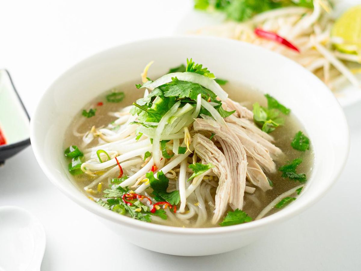 Semangkuk bakso dengan kuah kaldu bening dan mie ayam dengan topping ayam kecap.