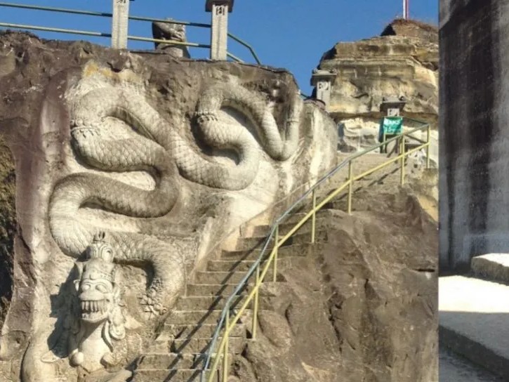 Gambar Tebing Breksi dengan dinding berukir dan orang-orang berfoto.