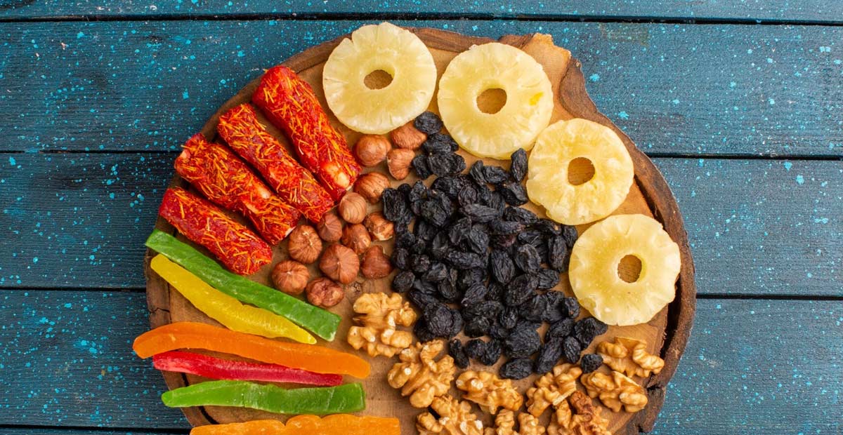 Gambar berbagai jenis buah kering seperti irisan pisang, mangga, dan nangka dalam mangkuk.