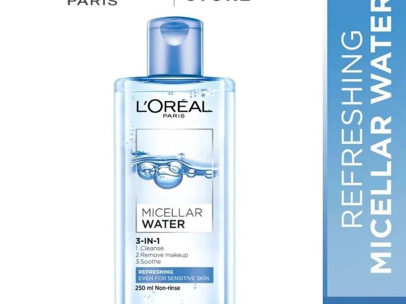 Gambar botol L'Oréal Paris Micellar Water 3-in-1 Refreshing dengan desain bersih dan ramping, mungkin dengan grafik samar yang menunjukkan lingkungan perkotaan atau barrier pelindung, dengan lata