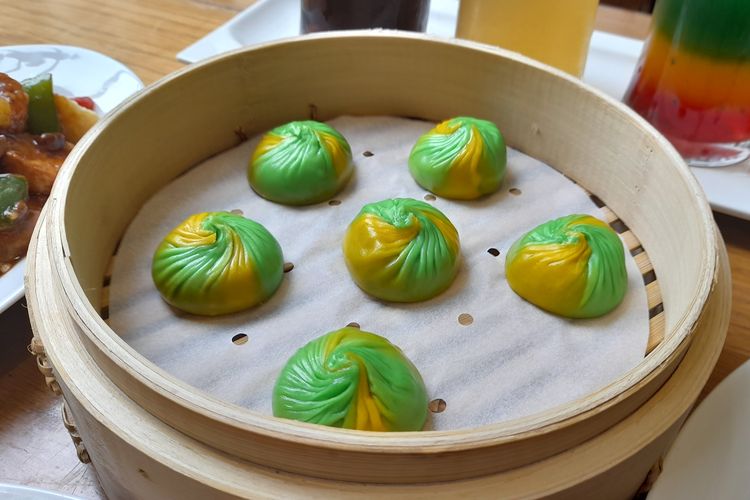 Piring berisi xiao long bao berwarna-warni yang menggiurkan di restoran Din Tai Fung.