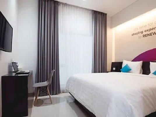 Gambar area umum hostel yang nyaman dengan para traveler sedang berbincang.