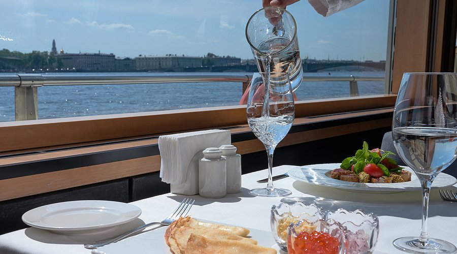 Meja makan restoran mewah dengan hidangan yang disajikan cantik dan gelas anggur.