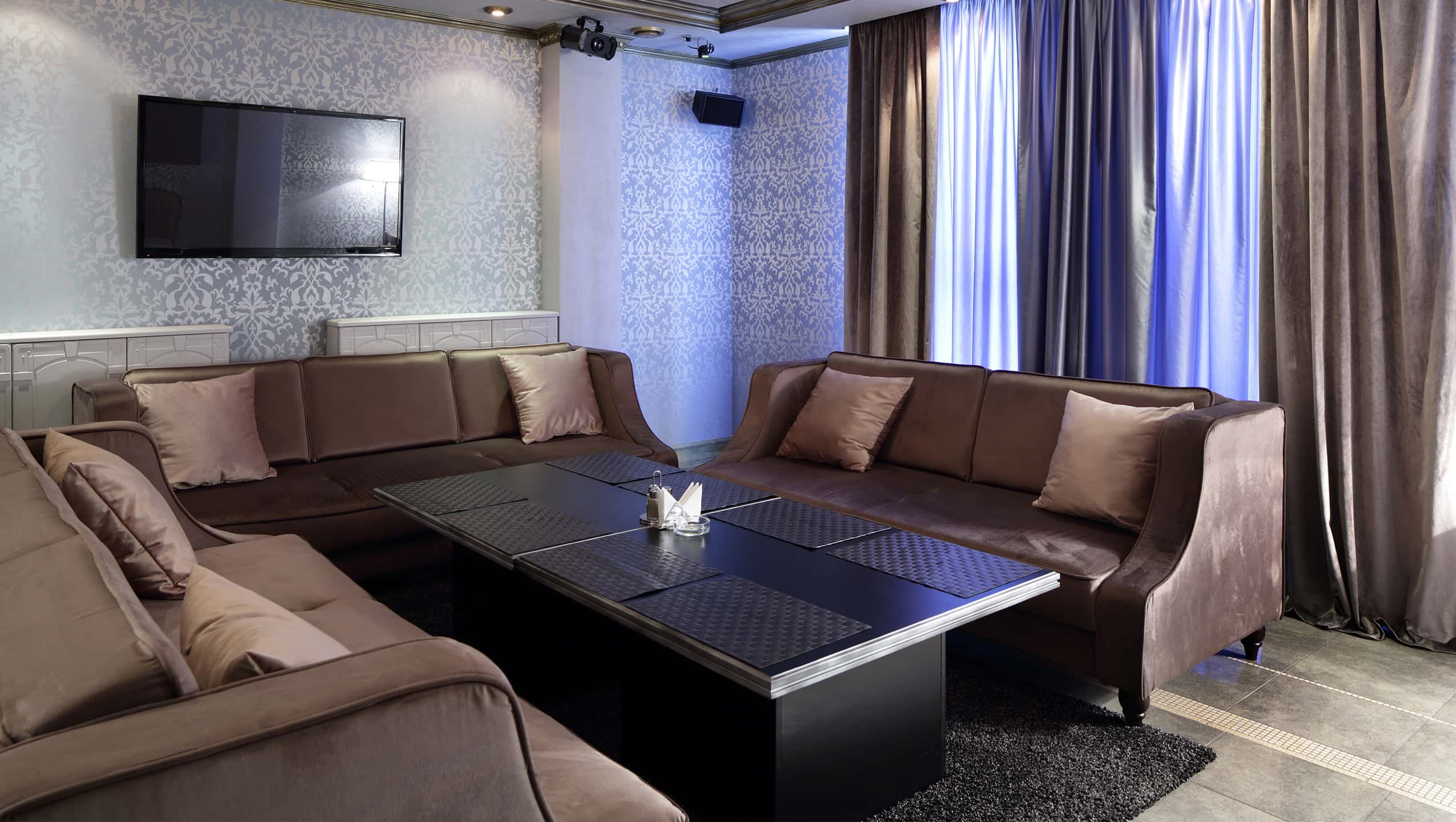 Interior ruangan karaoke VVIP yang mewah dengan sofa empuk, layar besar, dan pencahayaan elegan.