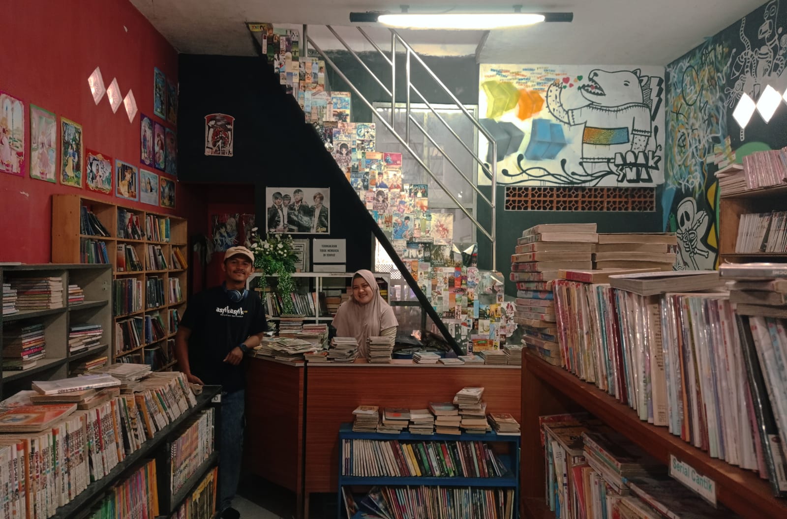 Gambar interior toko buku terang dengan rak buku akademik dan mahasiswa.