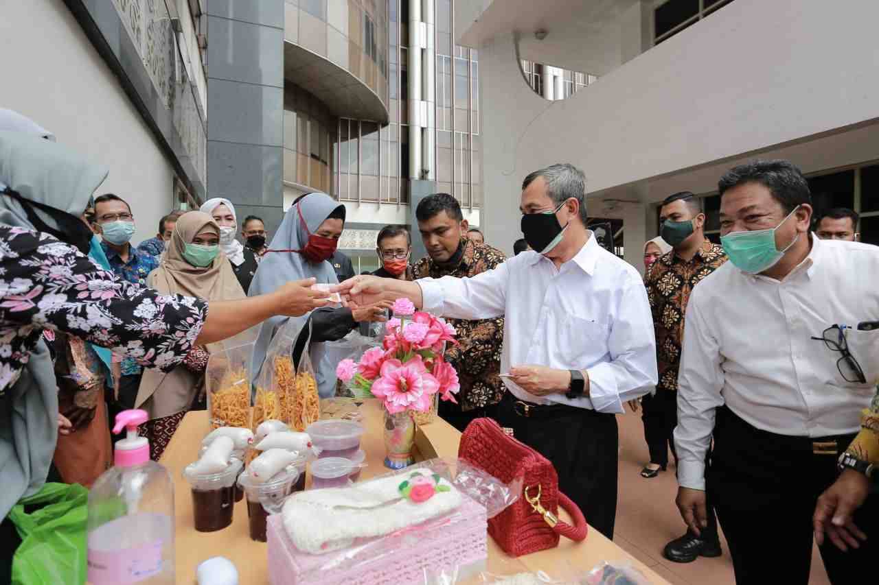 Beberapa orang mengantre di depan sebuah kedai kecil yang menjual kue balok di sore hari.