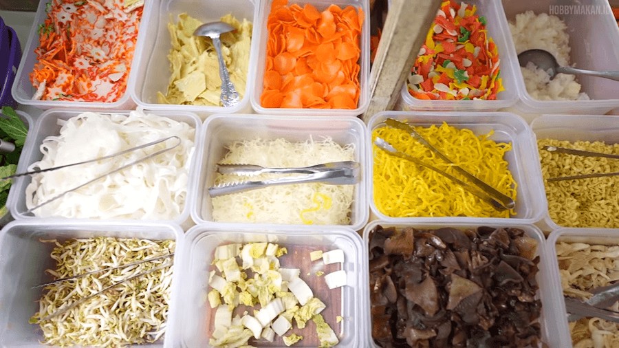 Mahasiswa menikmati seblak prasmanan di area ramai dekat kampus dengan berbagai pilihan topping.