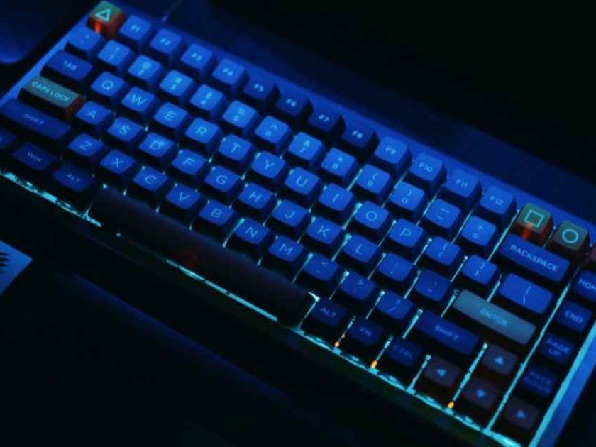 Gambar keyboard membran ramping dan senyap di meja kantor, menonjolkan desain sederhana dan minim fitur yang mengganggu, menyiratkan lingkungan kerja yang damai.