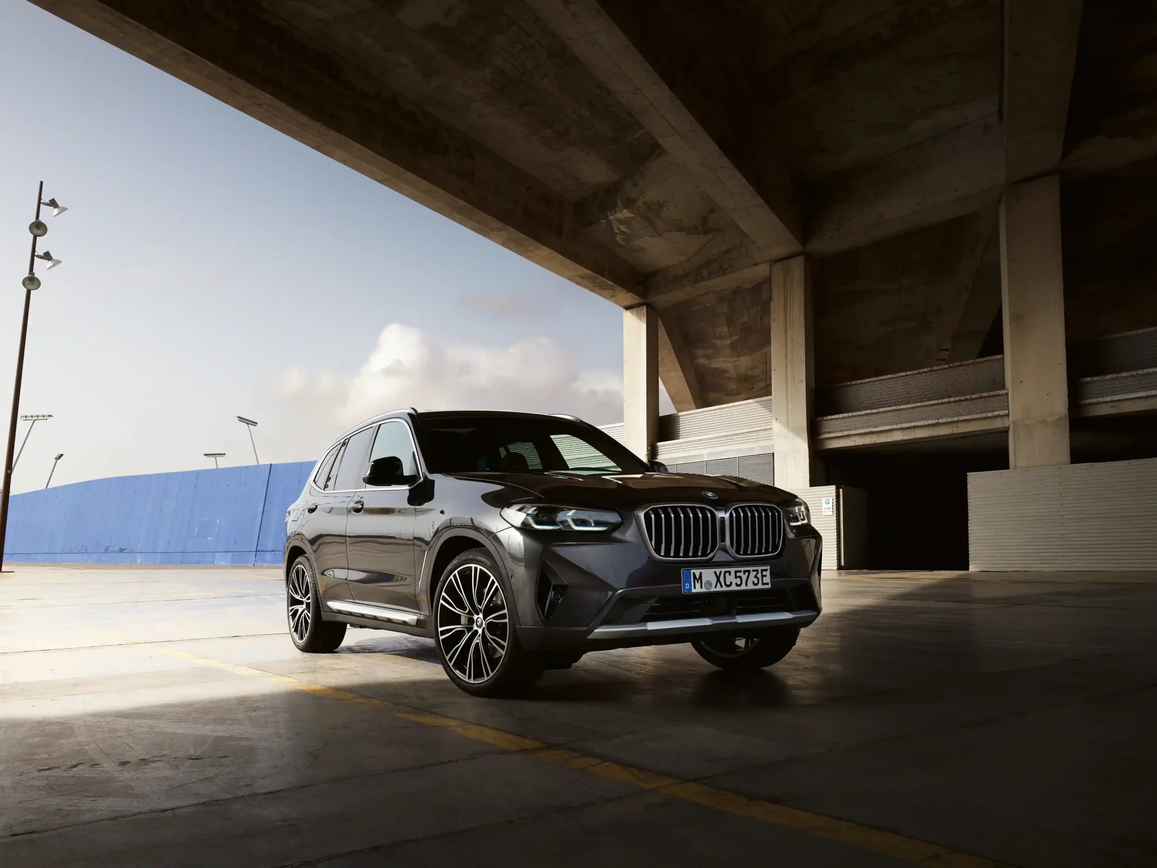 Gambar BMW X3 diparkir dengan elegan di lingkungan perkotaan modern atau di depan gedung mewah di Sunter, Jakarta Utara, menonjolkan desain SUV mewah dan kehadirannya yang kuat.