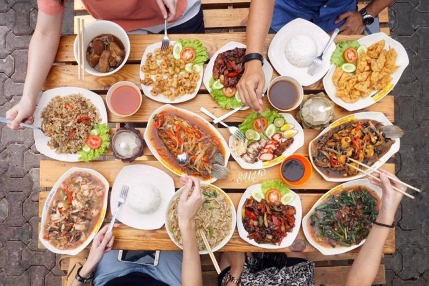 Berbagai jenis makanan sedang disajikan di foodcourt yang ramai.