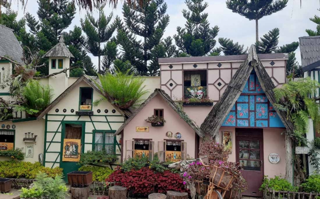 Keluarga sedang berfoto di depan salah satu bangunan unik di Farmhouse Lembang.
