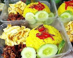 Seporsi nasi kuning di gerobak dengan telur dadar dan bihun goreng.