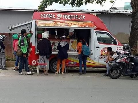 Pekerja sedang mengelas rangka sebuah food truck di bengkel karoseri.