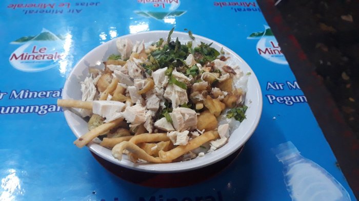 Semangkuk bubur ayam Barito dengan telur dan cheese stick.