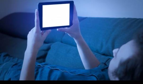 Layar ponsel menampilkan teks yang sangat jernih dengan latar belakang berwarna hangat, minim cahaya biru.