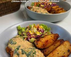 Potongan plant-based steak dengan saus jamur, kentang, dan sayuran di piring.