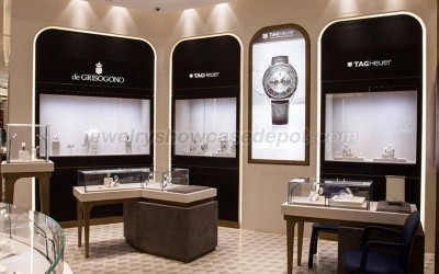 Jam tangan mewah di kotak display, dengan latar belakang butik mewah.