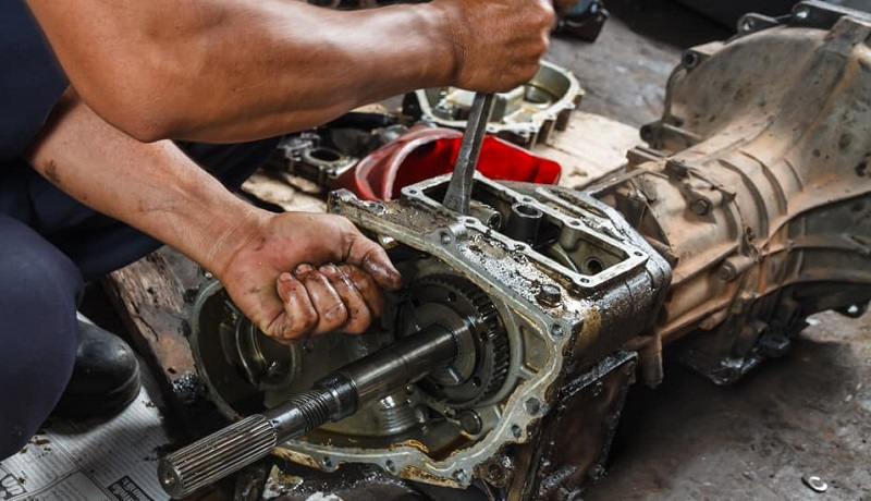 Teknisi memeriksa bagian transmisi mobil