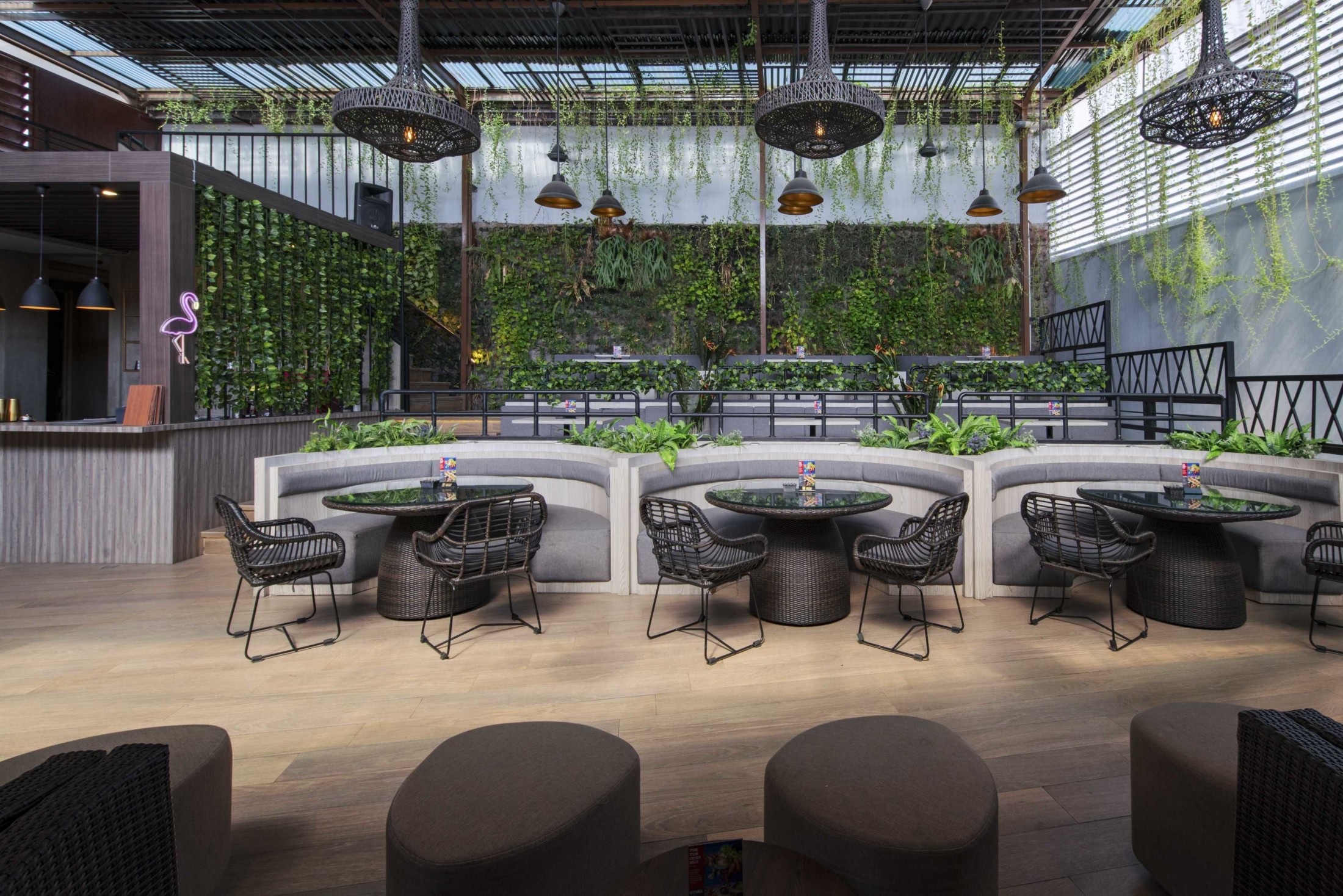 Interior coffee shop dengan desain minimalis tropis, banyak tanaman hijau.