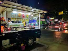 Suasana keramaian di warung martabak pada malam hari.
