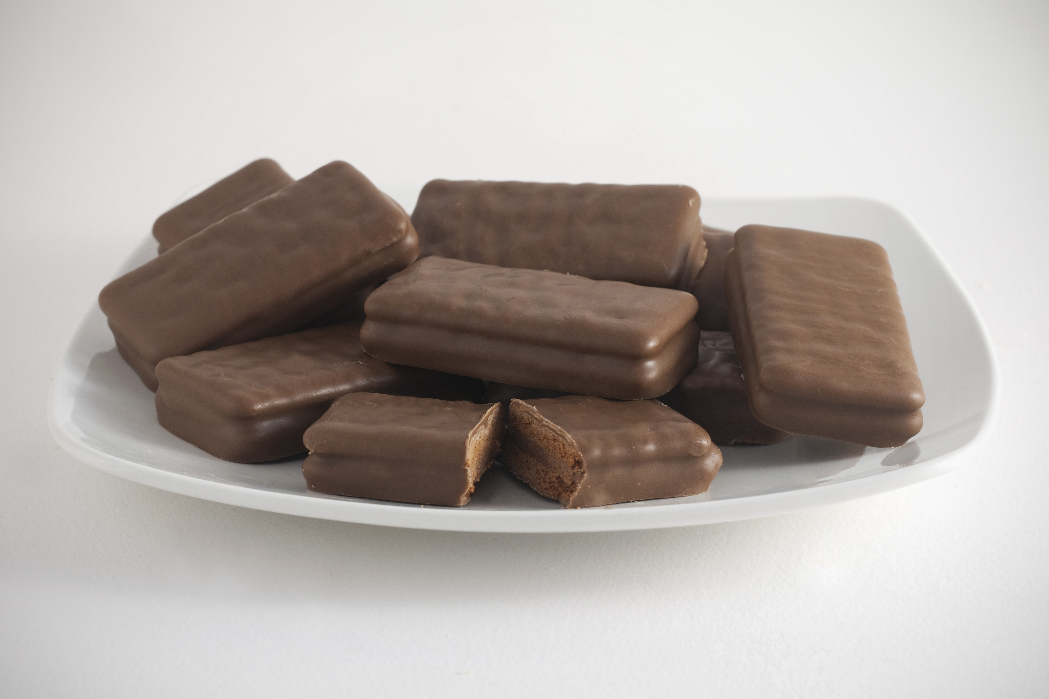 Gambar beberapa keping biskuit Tim Tam dengan lapisan cokelat yang tebal.