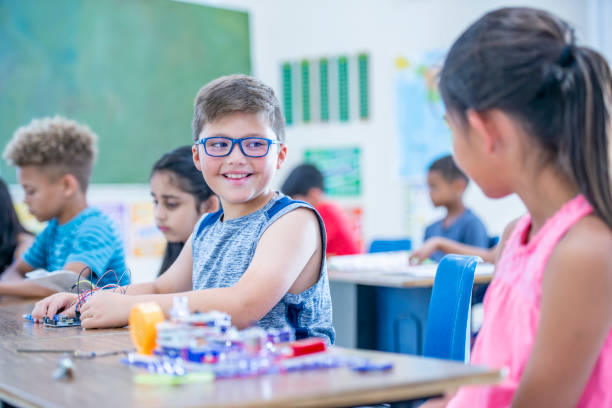 Gambar siswa-siswi dari berbagai etnis dan latar belakang tersenyum dan berinteraksi di halaman sekolah.