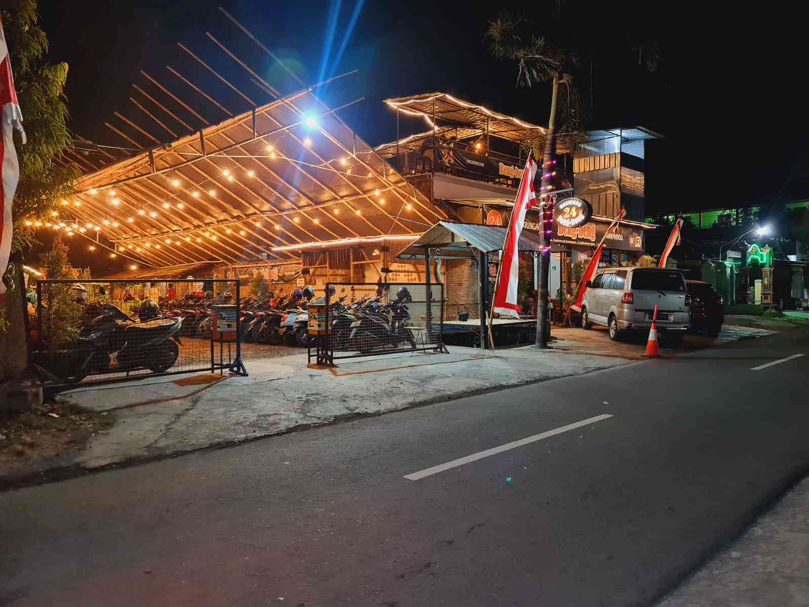 Suasana warmindo yang ramai di malam hari dengan mahasiswa yang begadang.
