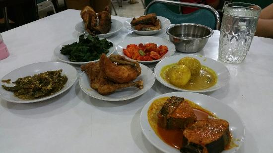 Meja makan dengan hidangan nasi Padang lengkap.