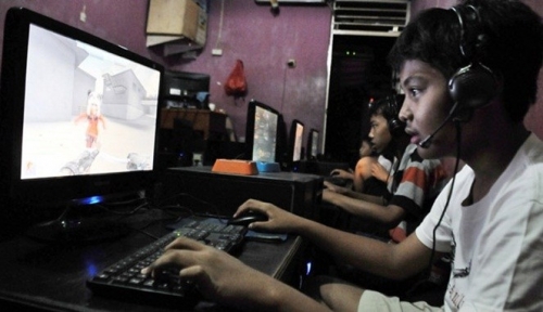 Anak muda di warnet sederhana, dengan monitor CRT dan suasana yang ramai namun akrab.