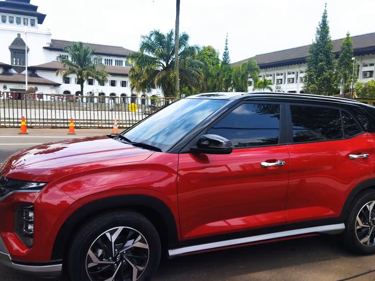 Gambar Hyundai Creta diparkir dengan gaya di jalanan modern atau di dekat kafe trendi di Dago, Bandung, menonjolkan desain futuristik dan daya tarik perkotaannya.