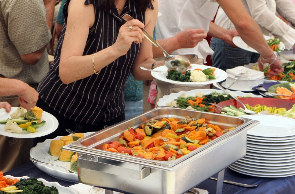 Meja buffet dengan berbagai hidangan yang tersaji rapi dan menggugah selera.