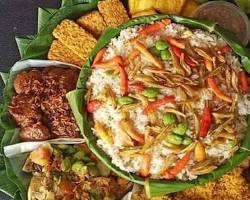 Nasi liwet komplit dengan ayam goreng, ikan asin, dan aneka lauk lainnya disajikan di nampan besar.