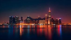 Gambar gedung apartemen modern dengan pemandangan jalan perbelanjaan yang ramai.