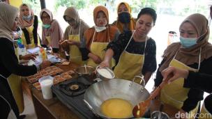 Sekelompok orang sedang mengikuti workshop memasak di dapur komunitas dengan instruktur.