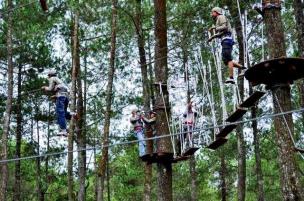 Orang sedang melakukan flying fox di Bandung Treetop Adventure Park.