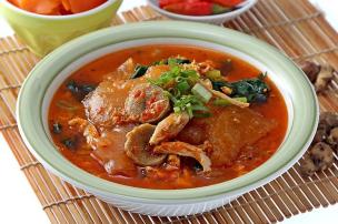 Semangkuk seblak jeletot dengan kuah merah menyala dan aneka topping.