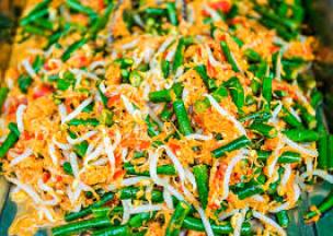 Semangkuk urap sayur dengan berbagai sayuran rebus dan kelapa parut berbumbu.