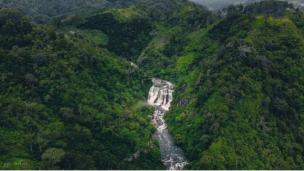 Curug Malela dengan air terjun yang melebar dan bebatuan hijau.