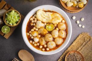 Semangkuk bakso aci komplit dengan kuah pedas dan topping pilus cikur.