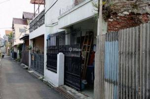 Gambar jalanan perumahan yang hidup di Sarijadi dengan rumah dan toko kecil.