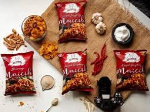 Tumpukan keripik singkong pedas Maicih dengan bubuk cabai.