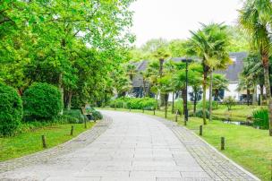 Gambar kompleks perumahan modern dengan jalanan bersih dan ruang hijau.