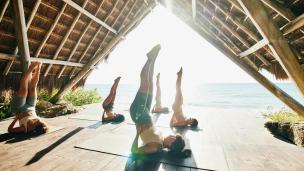 Orang bermeditasi atau melakukan yoga di studio yang tenang, atau menikmati fasilitas spa di wellness center, suasana relaksasi.