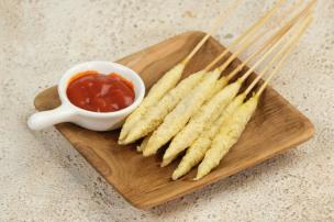 Beberapa tusuk telur gulung yang disajikan di piring dengan saus.