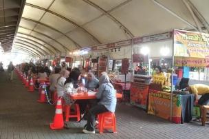 Suasana ramai di area street food Blok M Square dengan berbagai gerobak makanan.