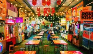 Suasana ramai di Margonda Street Food di malam hari dengan lampu terang dan berbagai stall makanan.